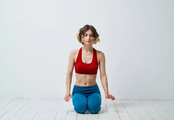 Sport kvinna yoga asana meditation i ett ljust rum gester med händerna — Stockfoto