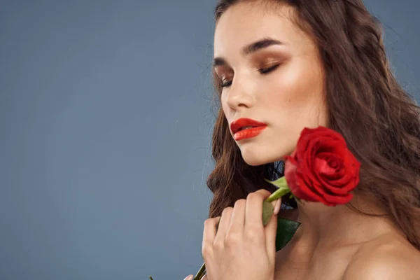 Femme avec une rose dans ses mains épaules nues soirée maquillage lèvres rouges — Photo