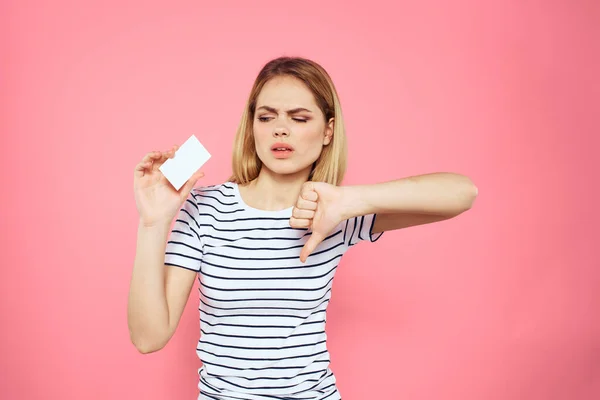 Donna con un biglietto da visita in mano una t-shirt a righe sfondo rosa Copia Spazio pubblicità — Foto Stock