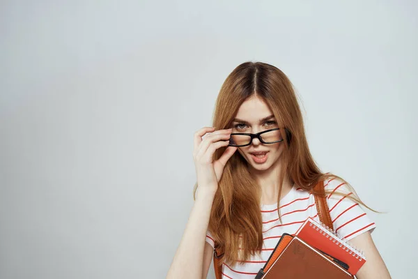 Kvinnlig student med anteckningsblock och ryggsäck på baksidan beskärda visa utbildning vetenskap glasögon — Stockfoto