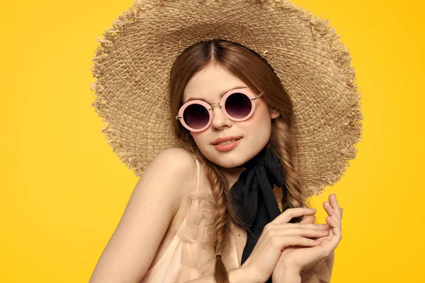 Şapkalı romantik bir kadın sarı arka planda eğleniyor ve güneş gözlüğü siyah kurdele modeli portresi takıyor. — Stok fotoğraf
