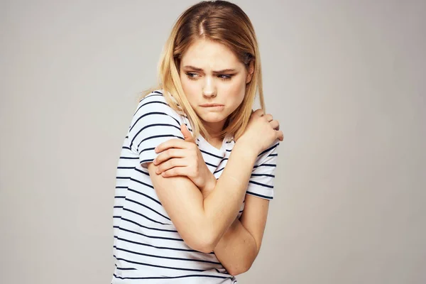 Çizgili tişörtlü bir kadın ellerini duygularının önünde tutar hoşnutsuz arka plan — Stok fotoğraf