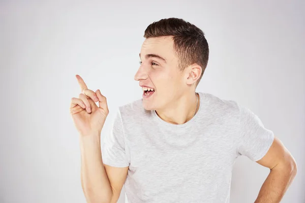 Man in een wit t-shirt emoties gebaren met handen close-up bijgesneden uitzicht licht achtergrond — Stockfoto