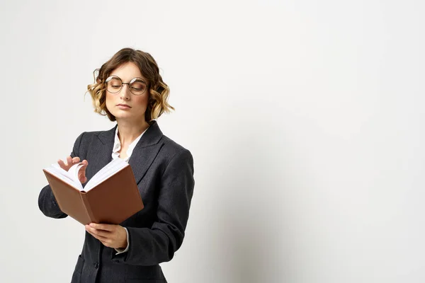 Donna al lavoro con libro in mano luce sfondo classico vestito occhiali testa — Foto Stock