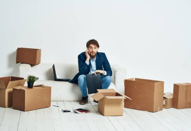 İş adamı kanepede oturmuş telefon kulübesinde konuşuyor.