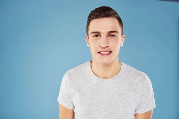 Emotionele man in wit t-shirt bijgesneden uitzicht op blauwe achtergrond levensstijl — Stockfoto