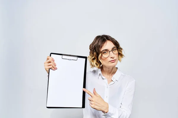 Femme d'affaires avec un dossier de documents blancs à la main sur un fond clair et modèle de lunettes de coiffure — Photo