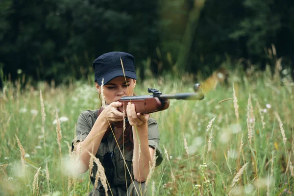 Kadın asker çimde barınak av silahı yeşil yapraklar — Stok fotoğraf