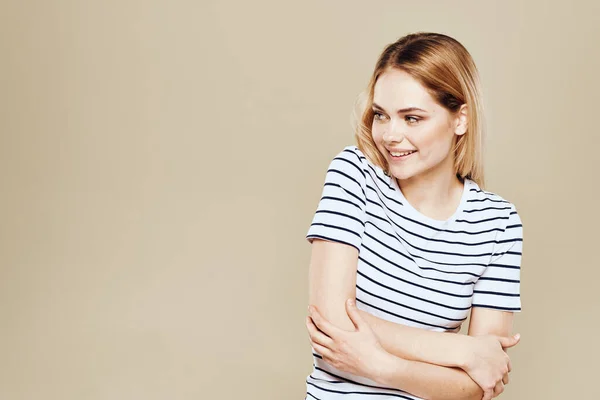 Söt blond randig t-shirt leende livsstil beige studio bakgrund — Stockfoto