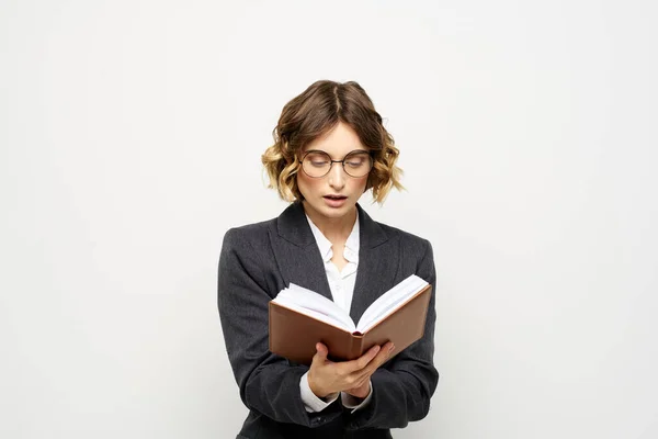 Donna al lavoro con libro in mano luce sfondo classico vestito occhiali testa — Foto Stock