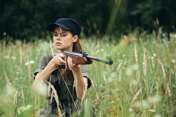 Mulher ao ar livre Com os olhos fechados, armas na mão, apontando macacão verde — Fotografia de Stock