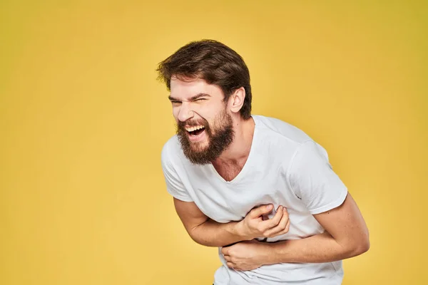 Бородатий чоловік біла футболка емоції жести руками весело жовтий фон — стокове фото
