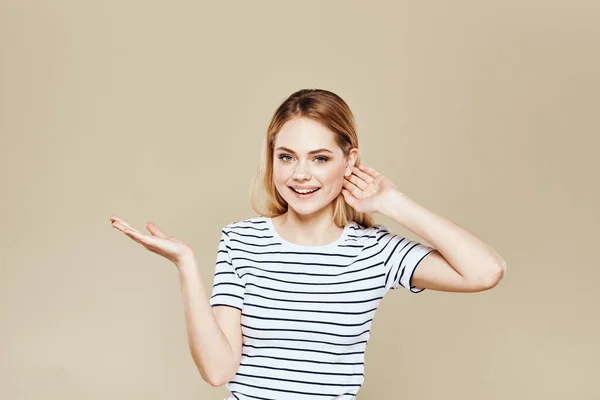 陽気女性ストライプTシャツスタジオベージュ背景ライフスタイルの感情 — ストック写真