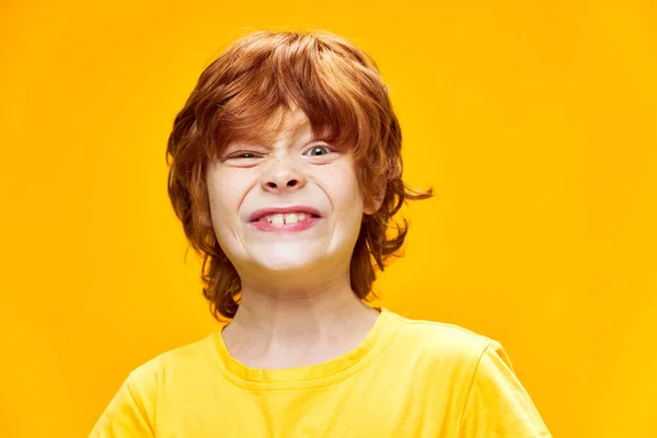 Rödhårig barngrimaser gul T-shirt — Stockfoto