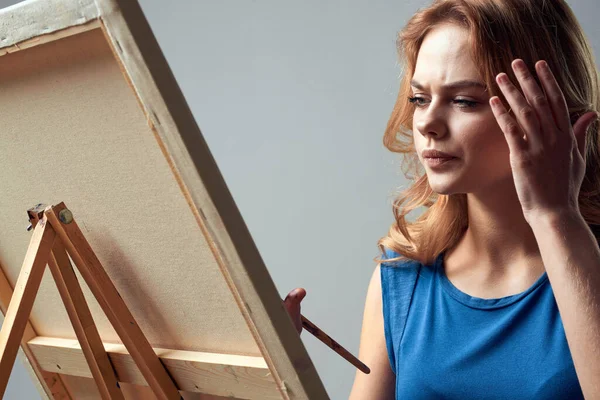 Woman artist with brush paint on easel art hobby light background — Stock Photo, Image