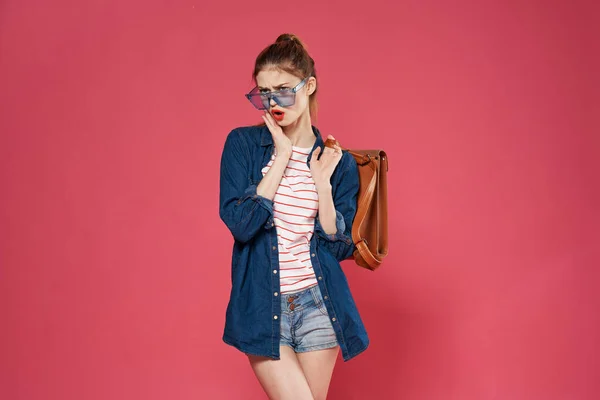 Donna glamour alla moda vestiti occhiali cosmetici rosa sfondo — Foto Stock