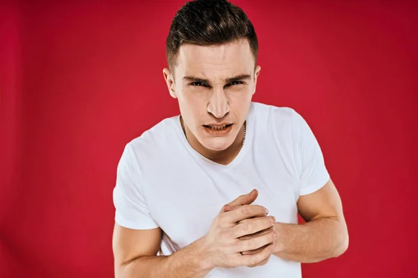 Emotionale Mann weißes T-Shirt missfallen Gesichtsausdruck rot isoliert Hintergrund abgeschnitten Ansicht — Stockfoto