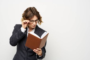 El fenerindeki kitapla çalışan kadın klasik takım elbiseli gözlüklü kafa.