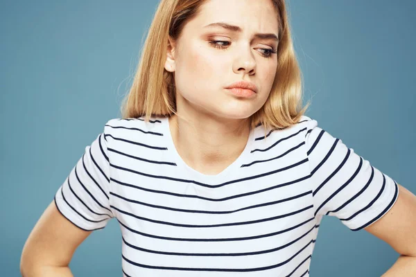 Kvinna bär randig t-shirt beskärd vy blå isolerad bakgrund missnöjd ansiktsuttryck — Stockfoto
