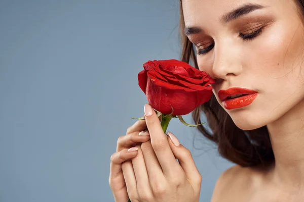 Femme avec une rose dans ses mains épaules nues soirée maquillage lèvres rouges — Photo