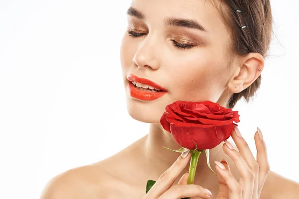 Urocza brunetka dziewczyna z makijażem na twarzy i czerwona róża w jej ręce — Zdjęcie stockowe