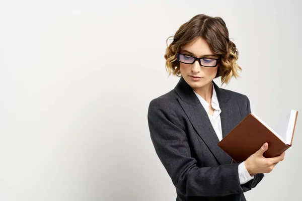 Femme d'affaires dans un costume classique avec un cahier à la main et des lunettes sur son visage Espace de copie — Photo