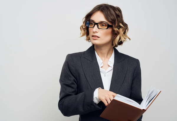 Donna d'affari con un libro in mano su uno sfondo leggero vestito classico acconciatura alla moda Copia Spazio — Foto Stock