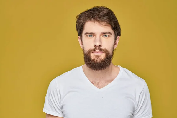 Uomo barbuto sulle emozioni bianco t-shirt divertente stile di vita giallo sfondo — Foto Stock