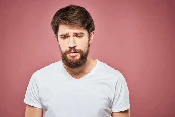 Homem emocional branco t-shirt triste facial expressão rosa fundo — Fotografia de Stock