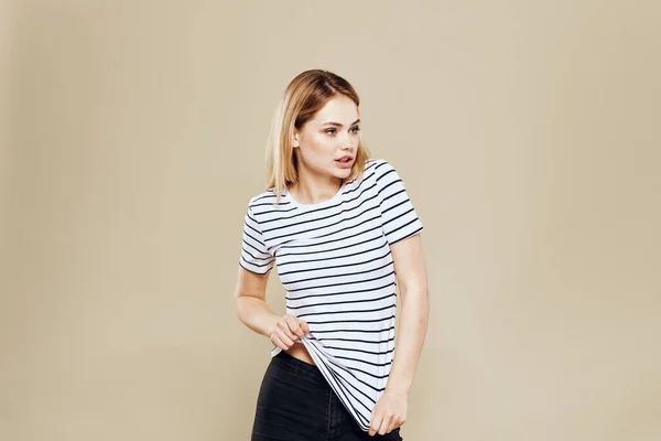 Vrolijke vrouw gestreepte t-shirt studio beige achtergrond lifestyle emoties — Stockfoto