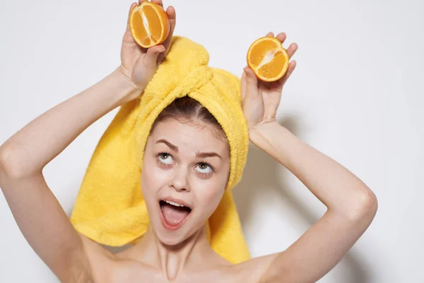 Wanita ceria dengan handuk kuning di kepalanya dengan jeruk bahu di tangan kesehatan kulit bersih — Stok Foto