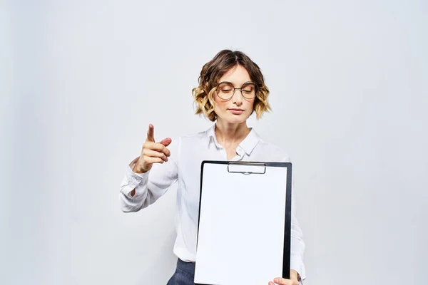 Donna d'affari con una cartella di documenti bianchi in mano su uno sfondo chiaro e modello di occhiali per acconciatura — Foto Stock