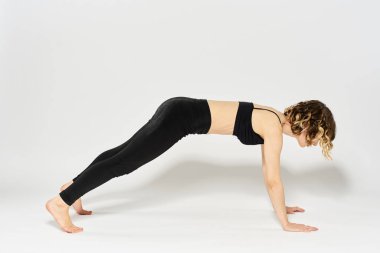 Sportif kadın egzersizi parlak bir odada yerde uzanmış jimnastik yaparken yapacak.