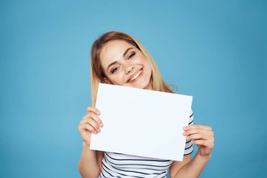 Elinde kağıt şeritli tişört tutan kadın Boşluğu kopyalanmış mavi arkaplan
