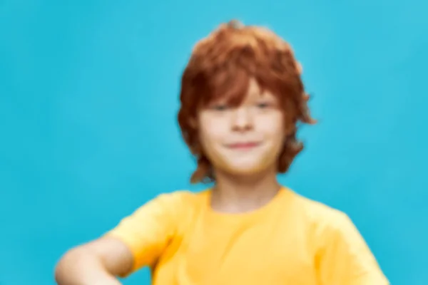 Rödhårig pojke leende gul t-shirt studio beskärd utsikt — Stockfoto