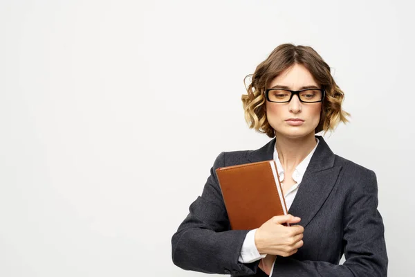 Donna d'affari con blocco note e occhiali lavoro luce sfondo ritagliato vista del modello tuta. — Foto Stock