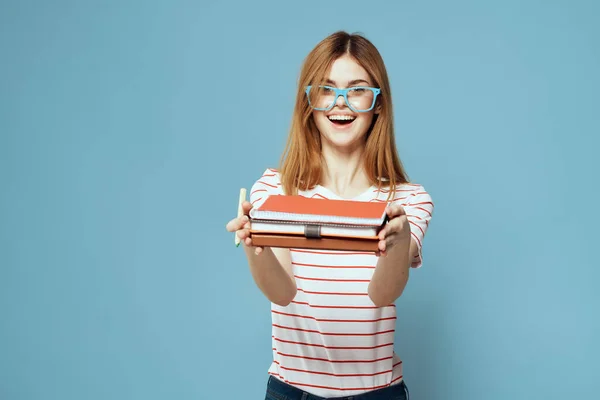 女の子でファッショナブルな眼鏡で手にノートブックで青の背景トリミングされたビューコピースペース — ストック写真