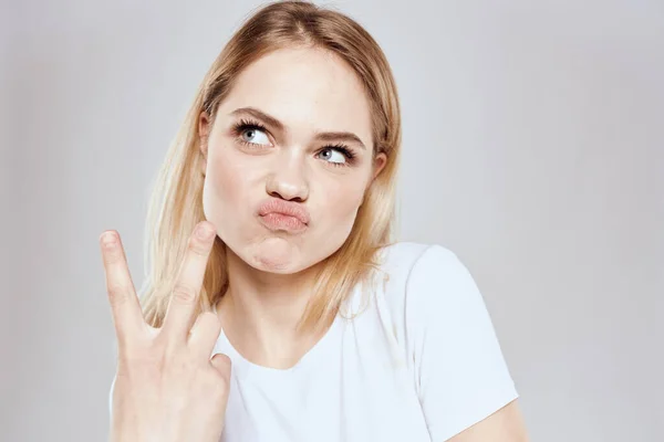 Femme blonde gaie en t-shirt blanc vue recadrée fond clair — Photo