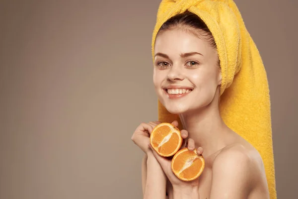 Wanita menarik dengan bahu telanjang dengan jeruk di tangan dipotong melihat latar beige — Stok Foto