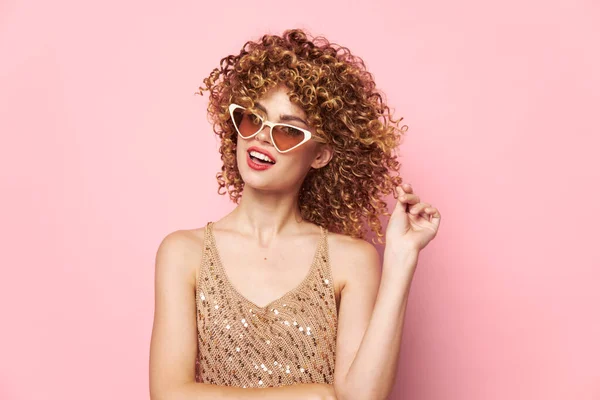 Привлекательная женщина Модные очки вьющиеся волосы розовый фон студии — стоковое фото
