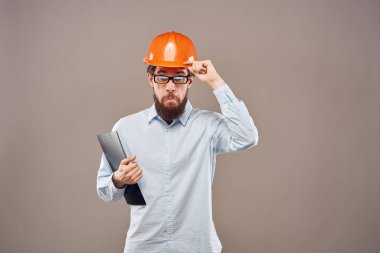 Sanayi belgelerine turuncu şapka takan duygusal bir adam.