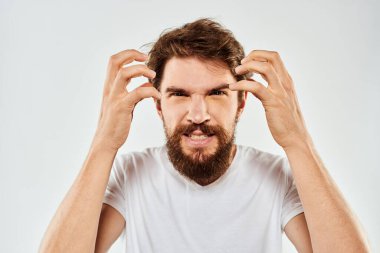 El kol hareketleri yapan sakallı bir adam. Beyaz tişört, stüdyo, duygu, ışık arka plan.