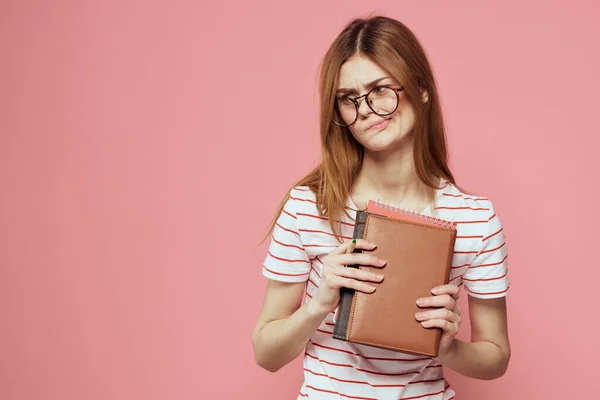 Young female student with books on pink background glasses on face education institute cropped view — Stock Photo, Image