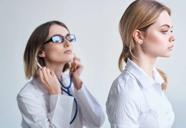 Профессиональный врач женщина со стетоскопом и пациентка вид сбоку — стоковое фото