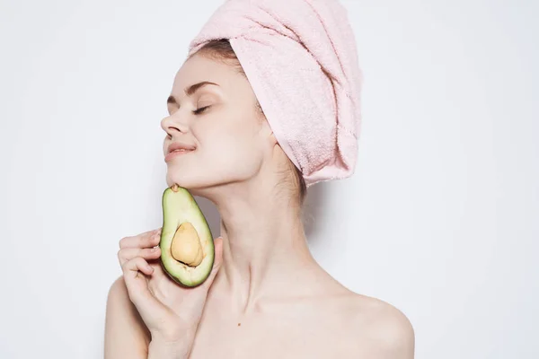 Mulher alegre vestindo uma toalha rosa na cabeça limpa vitaminas da pele cosméticos naturais — Fotografia de Stock