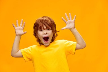 İfade veren kızıl saçlı çocuk avuçlarını kameraya gösteriyor.