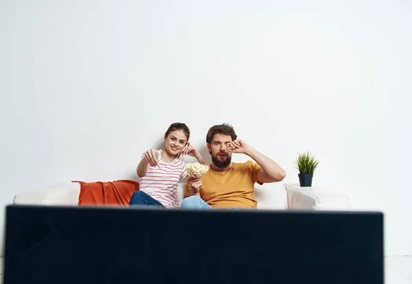 Hombre y mujer en el sofá viendo tv flor maceta — Foto de Stock