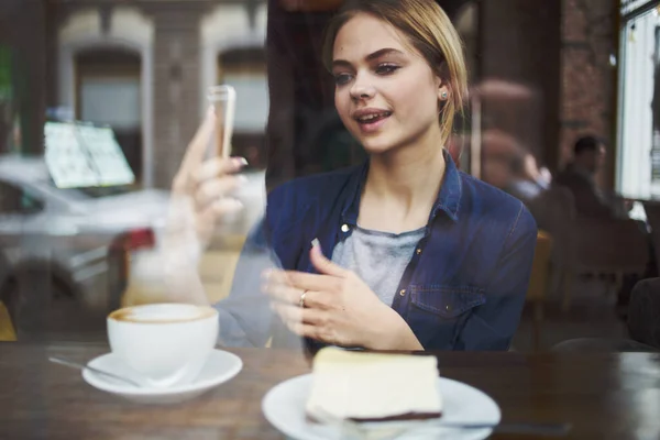 카페 테이블에 앉아 아침 식사를 하고 있는 여성 — 스톡 사진
