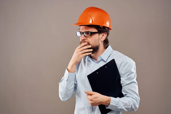 Emotional worker man in orange paint documents service construction beige background — Stock Photo, Image