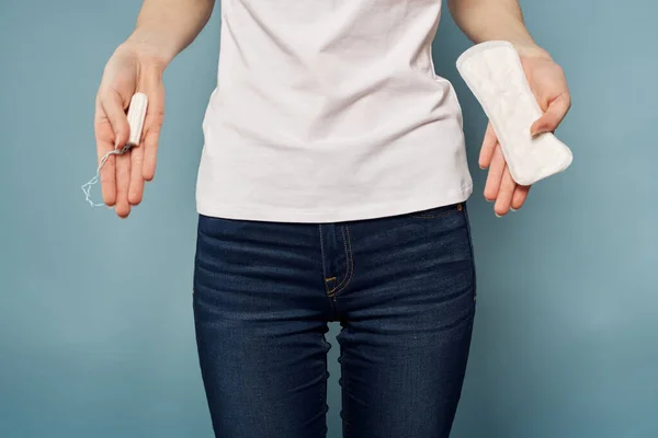 Chica con un tampón y una almohadilla en sus manos sobre un fondo azul higiene limpieza menstruación —  Fotos de Stock